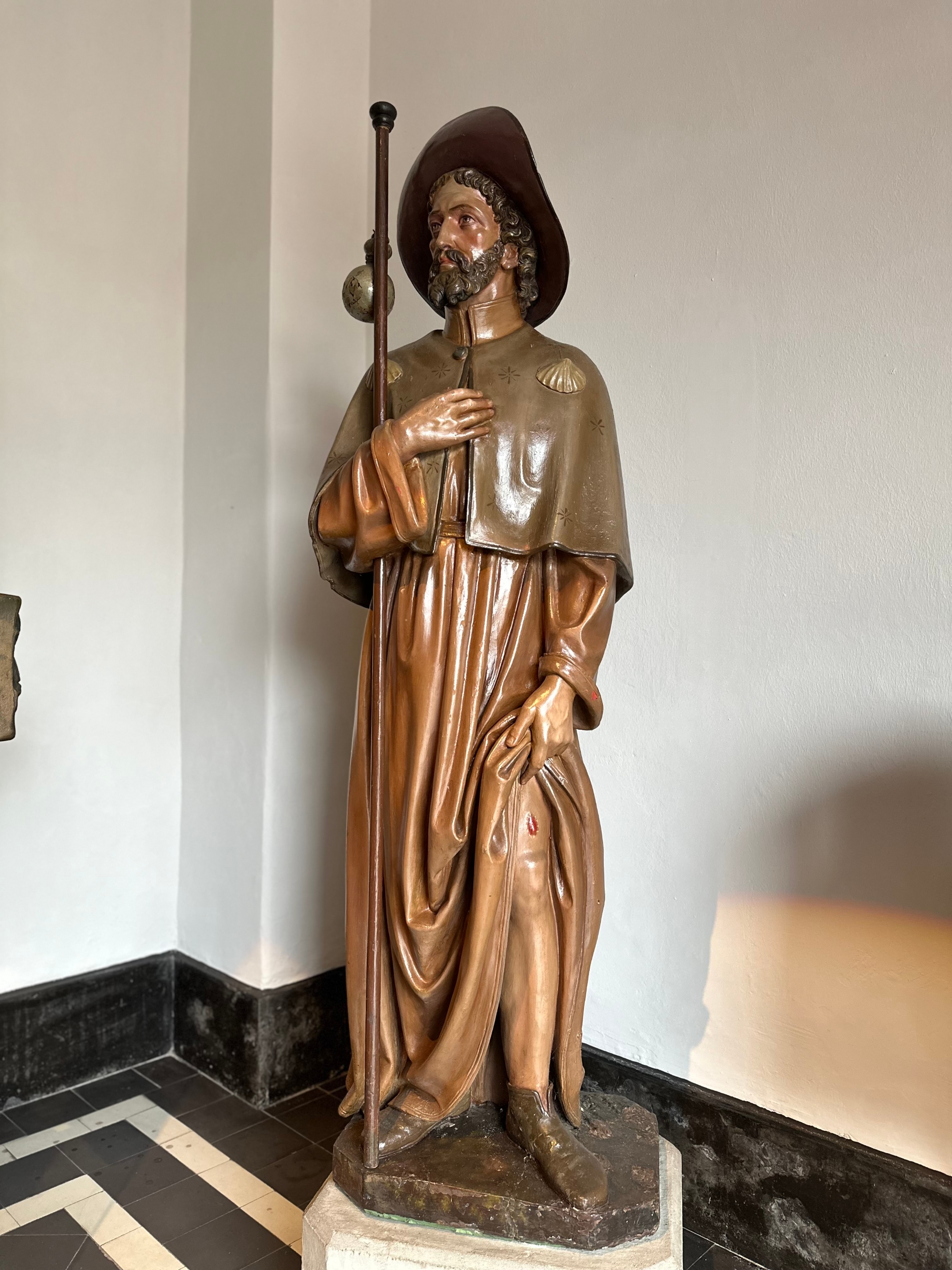 Die fast lebensgroße Holzfigur des Hl. Rochus steht im Eingangsbereich der Kirche